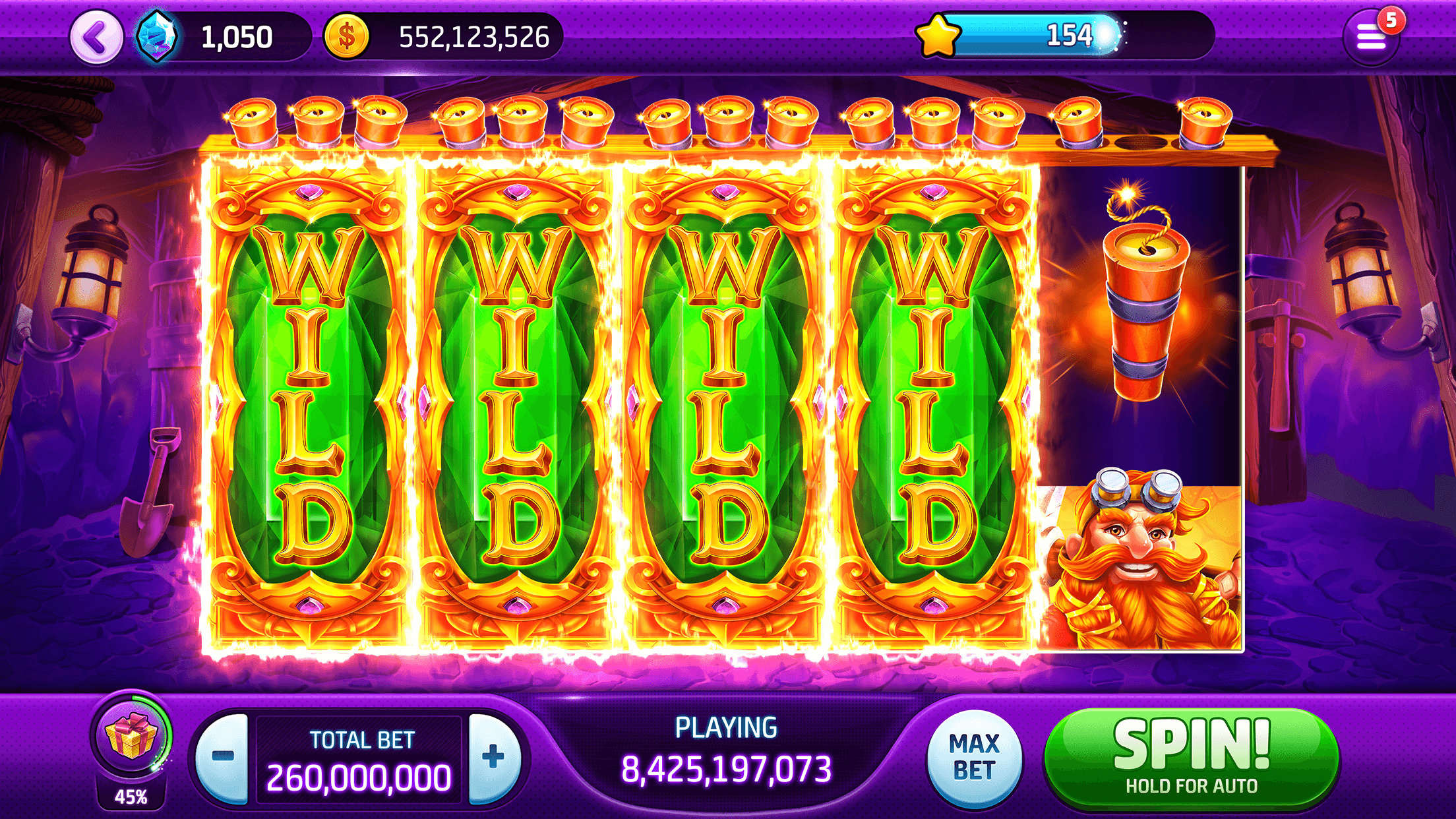 A mining-themed Slotomania slot with four reels turned fully wild and a stick of dynamite on the fifth, with the total bet and SPIN button along the bottom